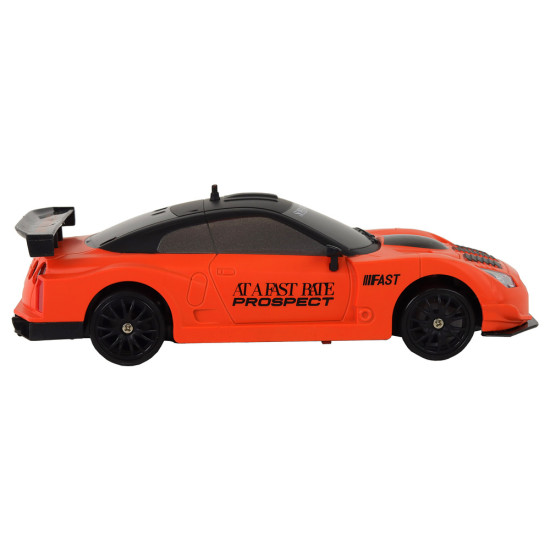 Nuotoliniu būdu valdomas sportinis automobilis R/C 1:24 oranžinės spalvos keičiamais ratais Radijo bangomis valdomi žaislai